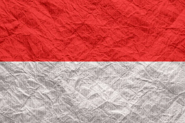 Monaco-Flagge auf altem zerknittertem Bastelpapier. — Stockfoto