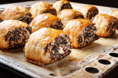 Bir fırın tepsisinde haşhaş tohumu ile gevrek taze pişmiş kurabiye. 