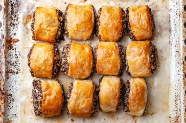 Bir fırın tepsisinde haşhaş tohumu ile gevrek taze pişmiş kurabiye. 