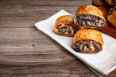 Ahşap bir arka plan üzerinde haşhaş tohumu ile gevrek taze pişmiş kurabiye.