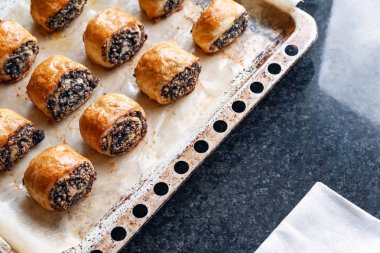 Bir fırın tepsisinde haşhaş tohumu ile gevrek taze pişmiş kurabiye. 