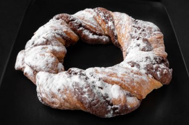 Pudra şekeri serpilmiş yakın çekim çikolatalı kurabiye halkaları. 