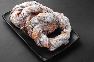 Çikolata çerez halkaları pudra şekeri serpilir. 