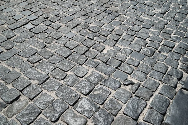 Stone road lined with stone blocks street. The texture of masonry stone.