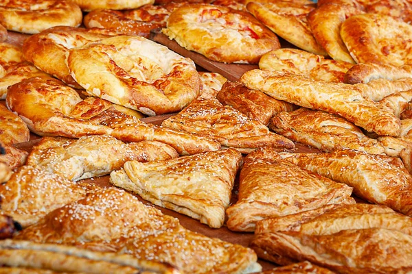 Street food. Hot fresh freshly baked cheese and sesame buns on the counter of a street diner.