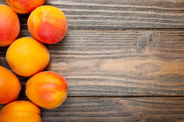 Ahşap arka planda kayısı. Üst görünüm taze sulu kayısı ahşap bir masaya yığılmış. 