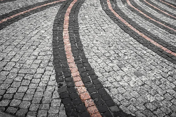 Stenväg asfalterad med gatstenar i olika färger på gatan. Konsistens av den gamla Stenvägen. — Stockfoto