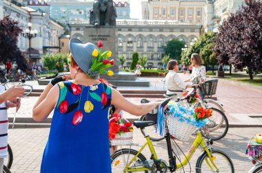 Kiev, Ukrayna - 27 Haziran 2019: Kızlar Bisiklet Show-Kiev Döngüsü Chic. Bir kadın bisiklet geçit töreninde çiçek ile mavi elbise ve şapka kadın. 