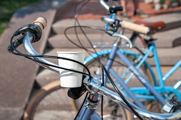 Kiev, Ukraine - 27 juin 2019 : Spectacle de vélo pour filles-KYIV CYCLE CHIC. Gros plan d'une tasse en papier avec de l'eau fixée sur un vélo . — Photo