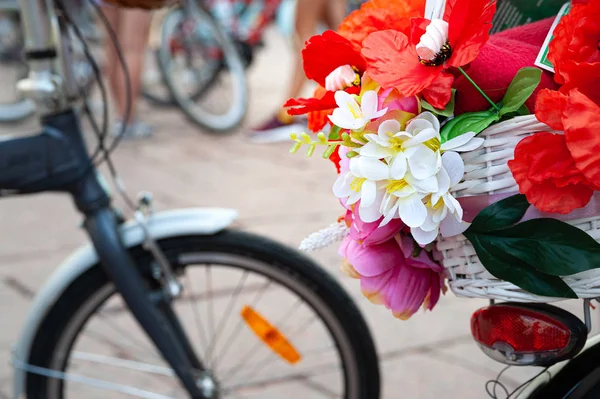 Kiev, Ucrania - 27 de junio de 2019: Girls 'Bike Show-KYIV CYCLE CHIC. Primer plano de una cesta con flores rojas y blancas en bicicleta . — Foto de Stock