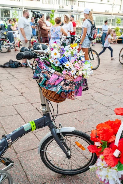 Kijów, Ukraina-27 czerwca 2019: Girls ' Bike show-Kijów Cycle Chic. Kosze z czerwonymi, białymi, żółtymi i niebieskimi kwiatami na rowerze. — Zdjęcie stockowe