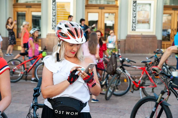 Kijów, Ukraina-27 czerwca 2019: Girls ' Bike show-Kijów Cycle Chic. Dziewczyna w kasku używa smartfona w pobliżu rowerów na kobiecej paradzie rowerowej. — Zdjęcie stockowe