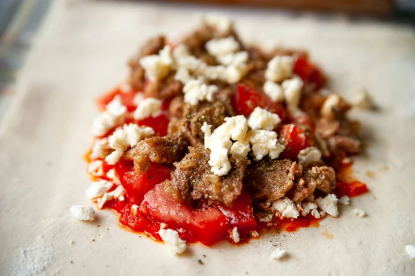 Gros plan sur la garniture de tomates avec de la viande, du fromage et de la sauce au piment rouge avec des épices pour burritos . — Photo