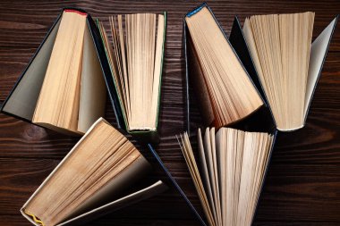 Eski kitaplar. Masaya istiflenmiş eski açık kitapların üst görünümü.