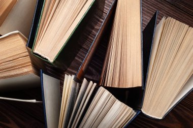 Eski kitaplar. Karanlık bir arkaplan üzerine açık eski kitapların yakın çekim yığını. 