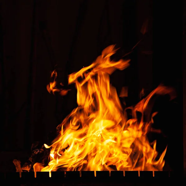 Fuego. Fuego brillante ardiendo por la noche. Un fuego en la parrilla, chimenea y hogar . —  Fotos de Stock