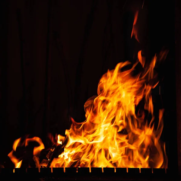 Fuego. Fuerte quema de fuego por la noche. Hoguera en la barbacoa, chimenea y hogar . — Foto de Stock