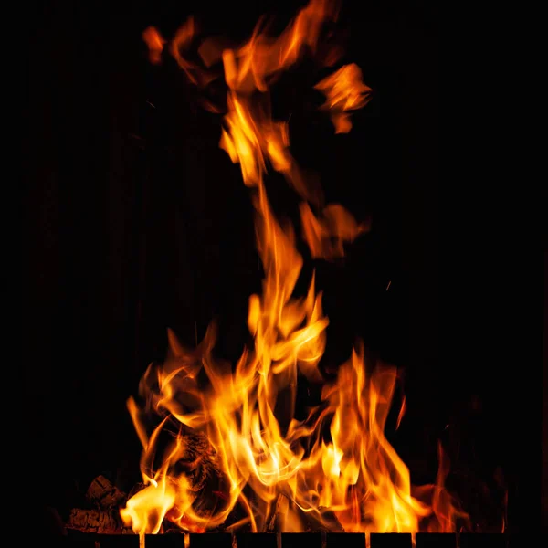 Llamas de fuego. Fuego ardiente por la noche. Fuerte hoguera en la barbacoa, chimenea y hogar . — Foto de Stock