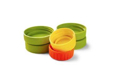 Geri dönüşümlü plastik şişe kapaklarının yakın çekimi. Beyaz arka planda renkli PET kapakları. Ayrı çöp toplama yeri. Protez için plastik geri dönüşümü. Seçici odak. 