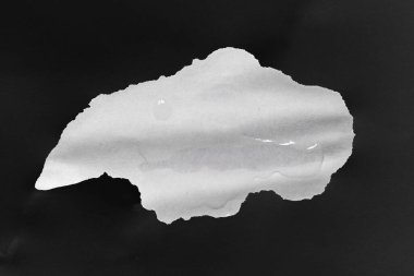 Wet paper. A piece of crumpled wet white paper on a black sheet. Abstract texture