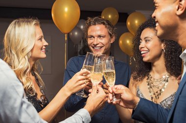 New year's eve kutlamak için şampanya ile toasting genç arkadaş grubu flüt. Mutlu çocuklar ve kızlar altın ve gümüş baloons ile yeni yıl arifesinde parti için kendi gözlük yükselterek. Zarif kadın ve çok ırklı erkek köpüklü şarap tadını çıkarın.