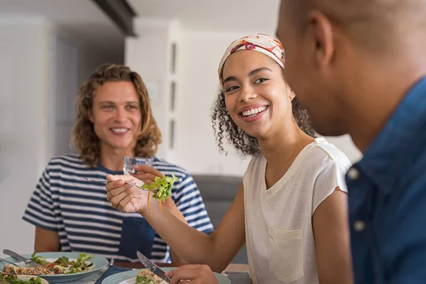 美しいアフリカ女性のランチに友達と新鮮なサラダを食べるします 家の昼食時の会話で幸せな陽気な友人 健康的な食事会お互いの若い友人 — ストック写真