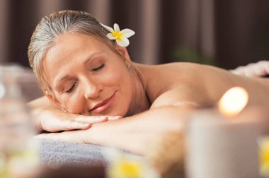 Güzel sarışın kadın rahatlatıcı spa vücut masaj sonra. Olgun kadın kapalı gözlerle masaj masanın üzerinde yatan portresi. Bir tembel Sağlık Merkezi'nde mum ile yatan kadın kıdemli.