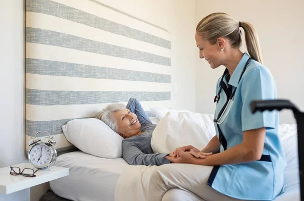 Vriendelijke Verpleegster Met Senior Vrouw Thuis Lachende Verpleegkundige Praten Met — Stockfoto