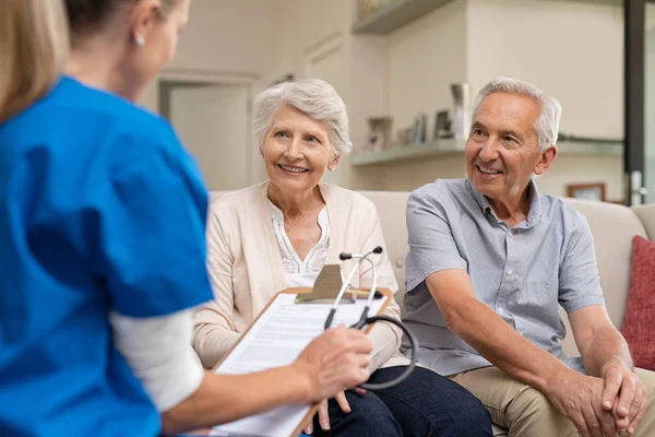 Verpleegkundige Tijdens Huis Met Senior Paar Bezoeken Dokter Holding Klembord — Stockfoto