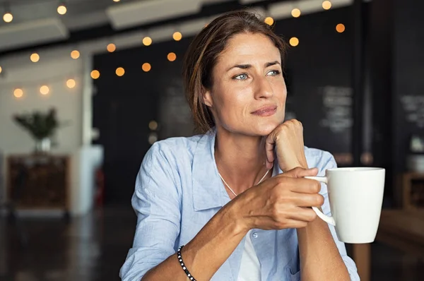 Tankeväckande Mogen Kvinna Sitter Cafeterian Håller Kaffekopp Medan Tittar Bort — Stockfoto