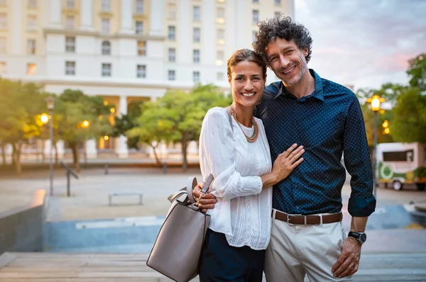 Sonriente Pareja Madura Elegante Casual Abrazando Mirando Cámara Con Ciudad — Foto de Stock