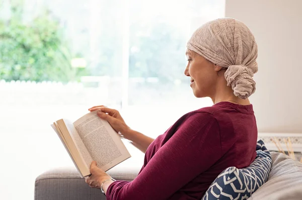 Kanker Vrouw Met Hoofddoek Lezen Van Een Boek Bank Thuis — Stockfoto