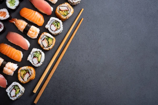 Draufsicht Auf Sushi Mit Bambusstäbchen Auf Schwarzem Hintergrund Hochwinkelige Ansicht — Stockfoto