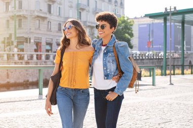Two women friends walking on street clipart