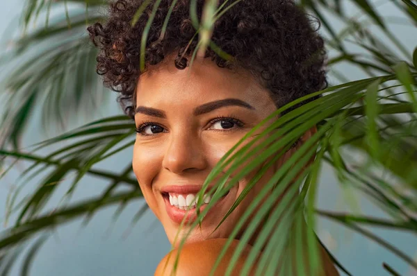 Краса молода жінка посміхається через пальмове листя — стокове фото