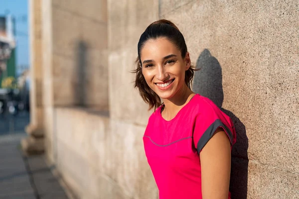 Sporty woman leaning on wall — Stock Photo, Image