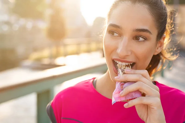 Sportieve vrouw energiereep eten — Stockfoto