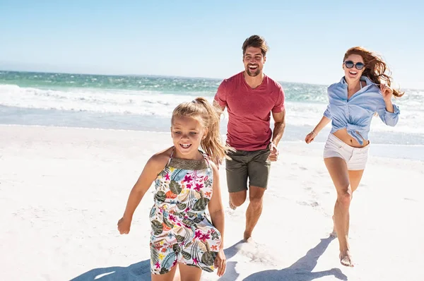 Jovem família feliz correndo na praia — Fotografia de Stock