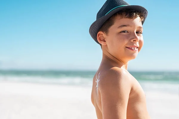 Liten pojke tittar kameran på stranden — Stockfoto