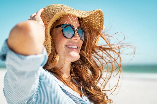 Mogen kvinna med stranden hatt och solglasögon — Stockfoto