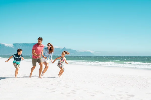 Ευτυχισμένη οικογένεια που τρέχει στην παραλία — Φωτογραφία Αρχείου