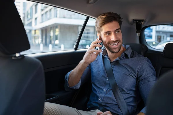 Young man talking over phone in taxi — Stock Photo, Image