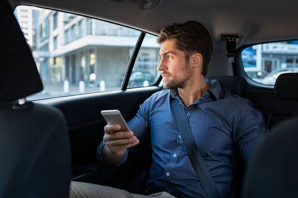 Muž sedící v autě pomocí chytrého telefonu — Stock fotografie