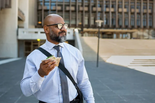 Businessman eating take away sandwich outdoor — Stock Photo, Image