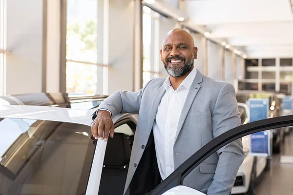 Счастливый взрослый черный мужчина в автосалоне — стоковое фото