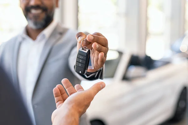 Salesman giving new car keys to customer — Stock Photo, Image