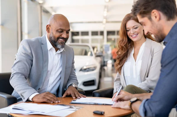 Man signing contract to buy new car