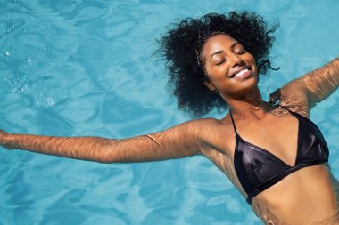 Yüzme havuzunda dinlenen Afrikalı kadın