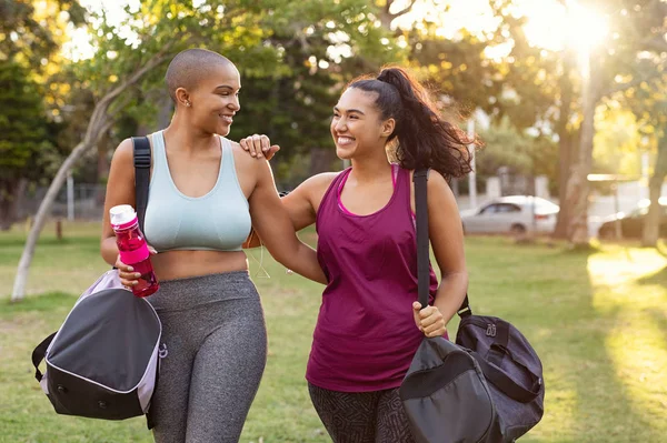Bochtige vrienden lopen naar huis na fitness oefening — Stockfoto
