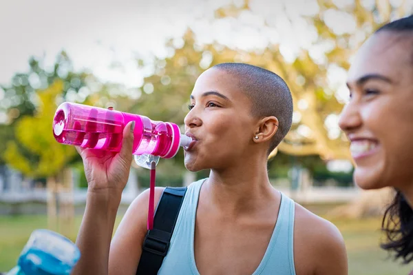 Спортивная женщина пьет воду после тренировки — стоковое фото